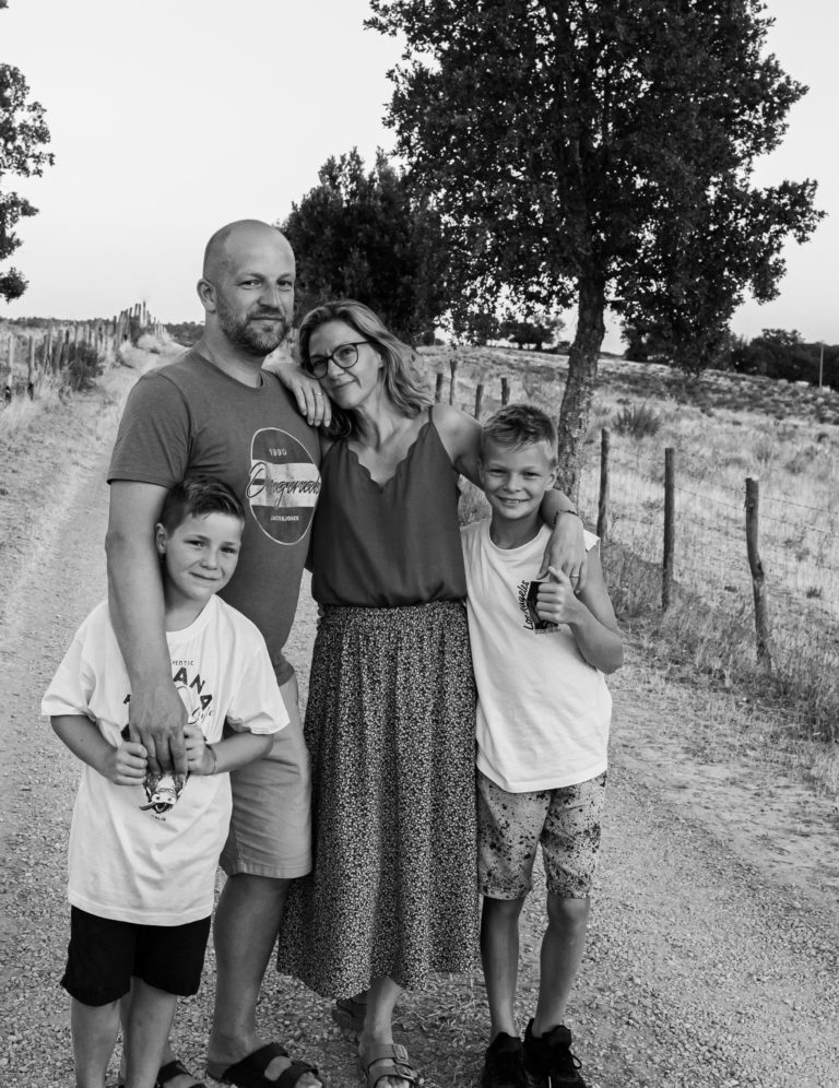 Natürliche Familienfotografie. Vierköpfige Familie als Gruppe auf einem Landweg in der Toscana.