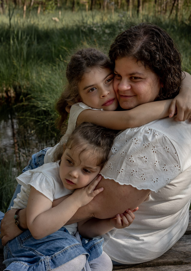 Familienfotografie. Mutter und ihre Töchter in einer innigen Umarmung.
