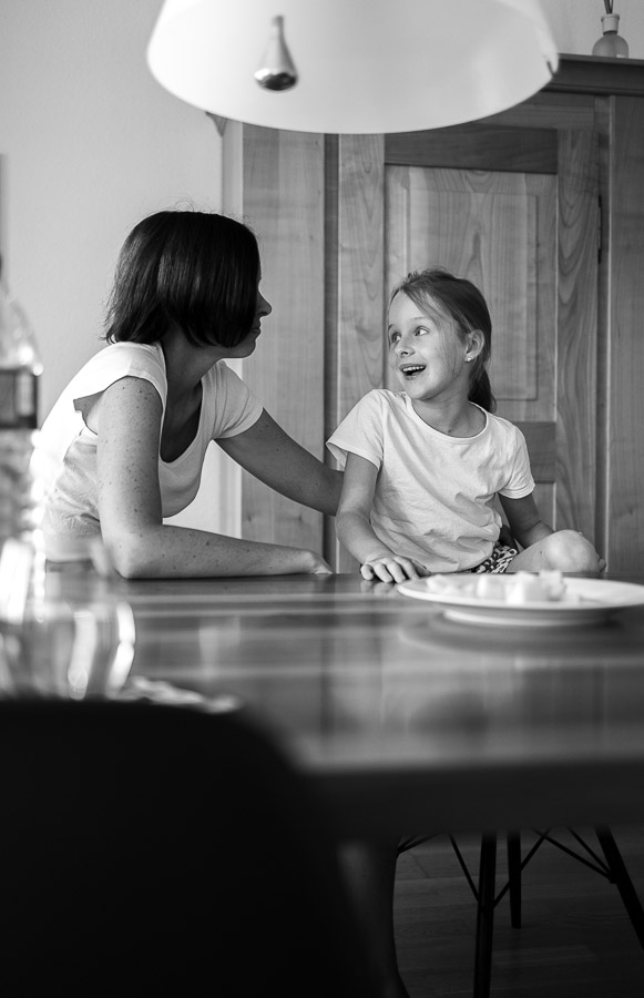 Mutter und Tochter unterhalten sich am Tisch.