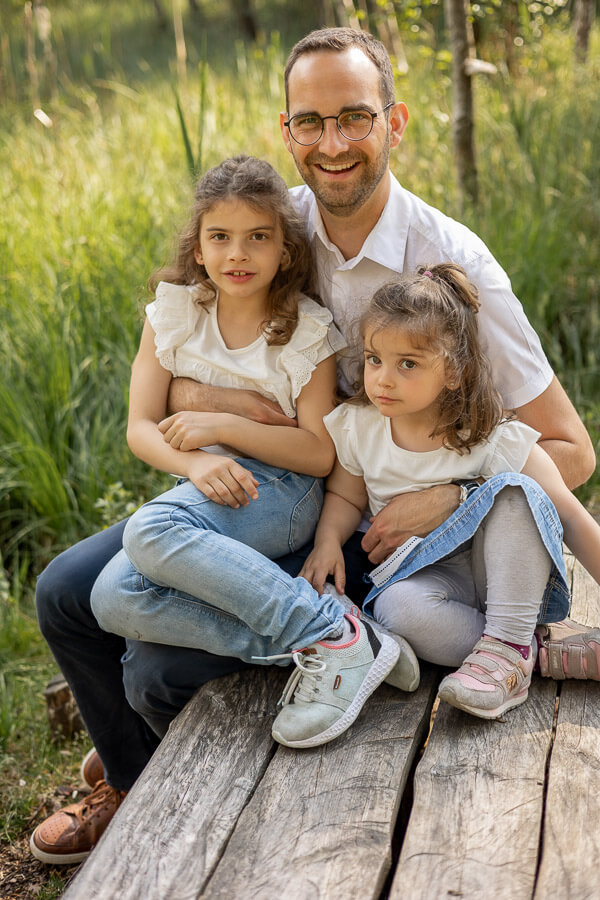 natürliche Familienfotografie. Vater mit seinen zwei Töchter.