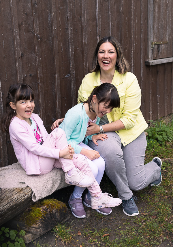 Mutter mit zwei Töchtern beim lachen im Park